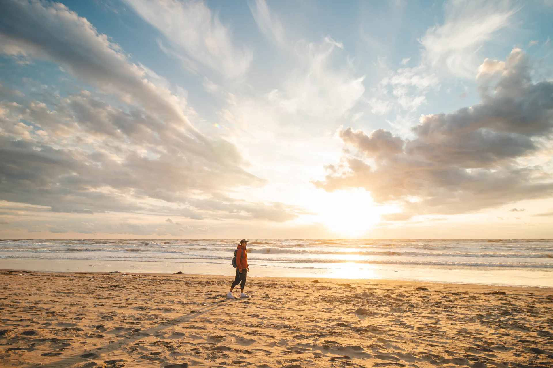 Guest walking along Zandvoort beach at sunset, a 10-minute walk from Ocean House Zandvoort